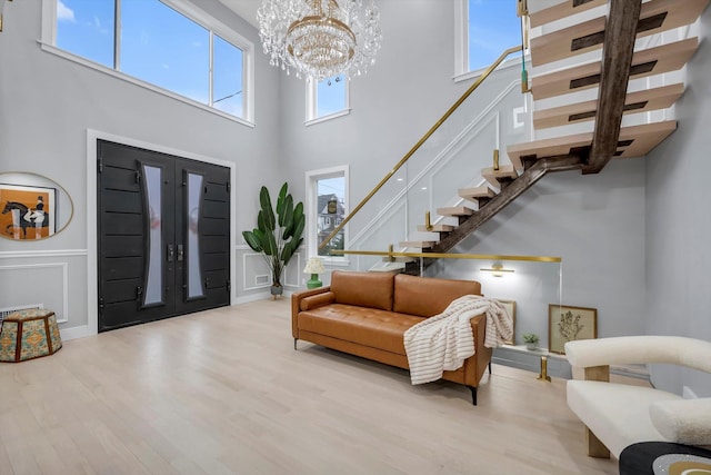 entrance foyer with an inviting chandelier, light hardwood / wood-style flooring, and a high ceiling