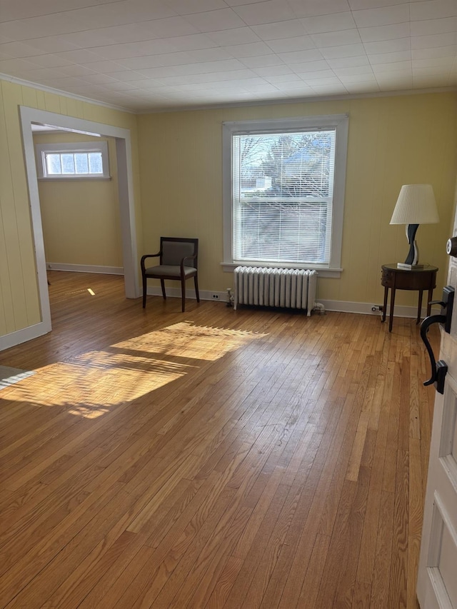 sitting room featuring a healthy amount of sunlight, wood-type flooring, and radiator