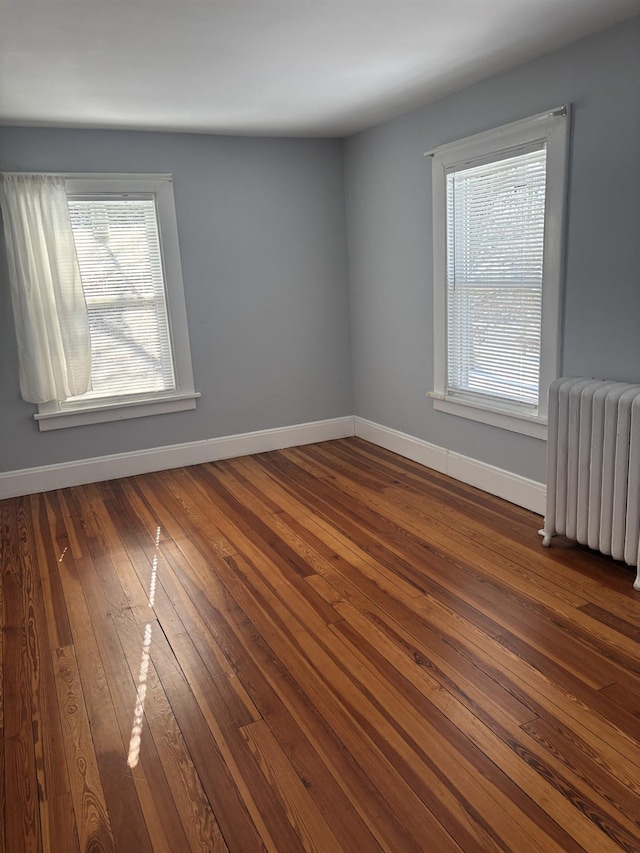 empty room with radiator and dark wood-type flooring