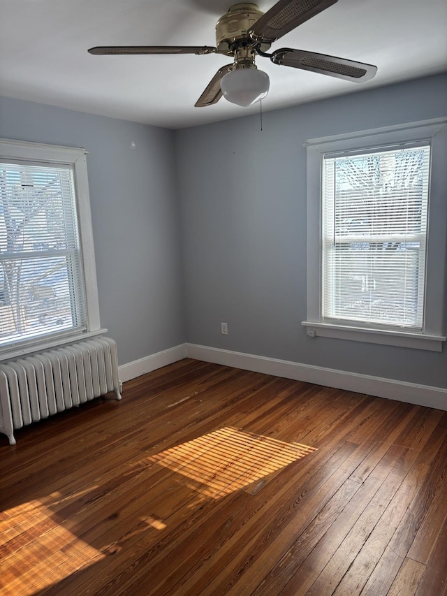 spare room with dark hardwood / wood-style flooring and radiator