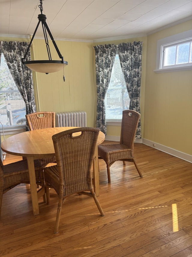 dining area with crown molding and hardwood / wood-style floors