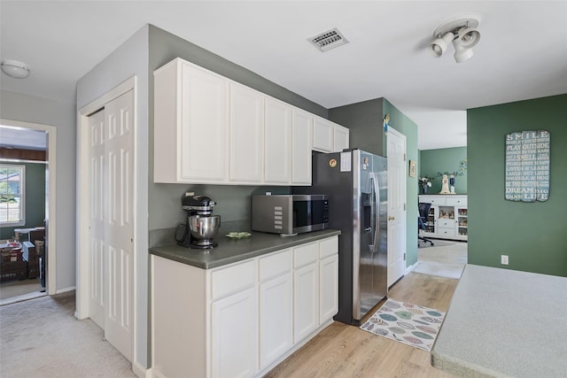 106 Williams Way S, Baiting Hollow, NY 11933 - kitchen with stainless steel appliances, white cabinets, dark countertops, and light wood-type flooring