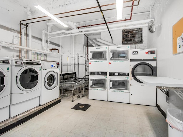 community laundry room featuring stacked washer and dryer, washing machine and dryer, and light floors