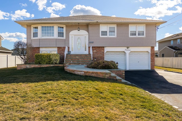 split foyer home with brick siding, driveway, an attached garage, and fence