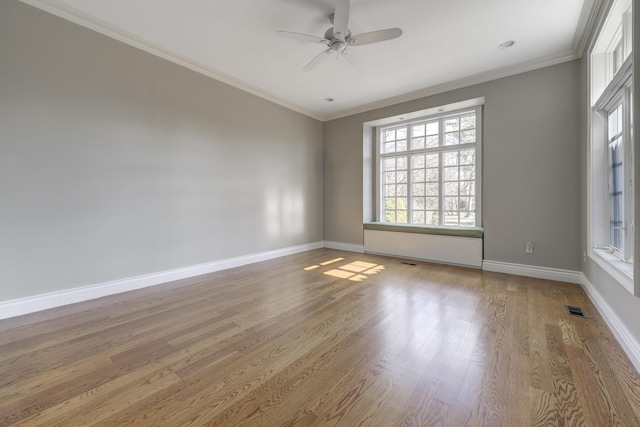 unfurnished room with baseboards, visible vents, crown molding, and wood finished floors