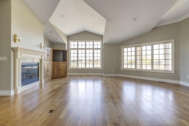 unfurnished living room with lofted ceiling, visible vents, wood finished floors, a tile fireplace, and baseboards