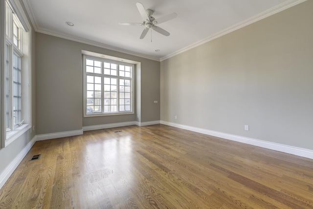 unfurnished room featuring visible vents, crown molding, baseboards, and wood finished floors