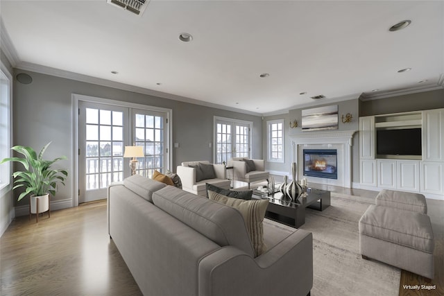 living area featuring crown molding, visible vents, light wood-style floors, a glass covered fireplace, and baseboards