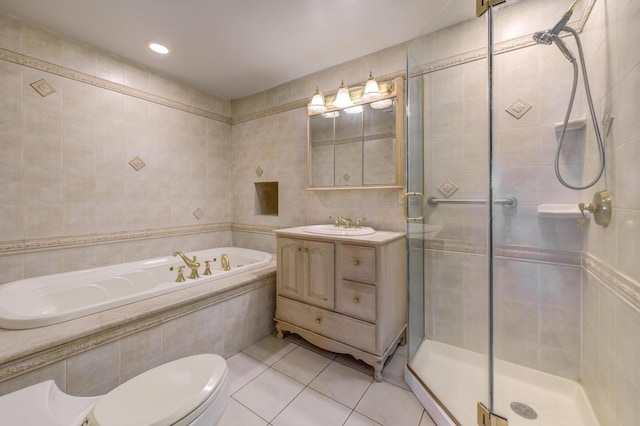 bathroom featuring a stall shower, toilet, a garden tub, tile patterned flooring, and tile walls