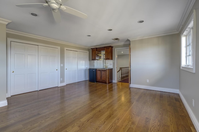 unfurnished living room with baseboards, visible vents, ornamental molding, and dark wood-type flooring