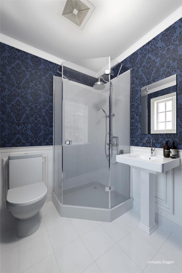 full bath with wallpapered walls, a shower stall, visible vents, and a wainscoted wall