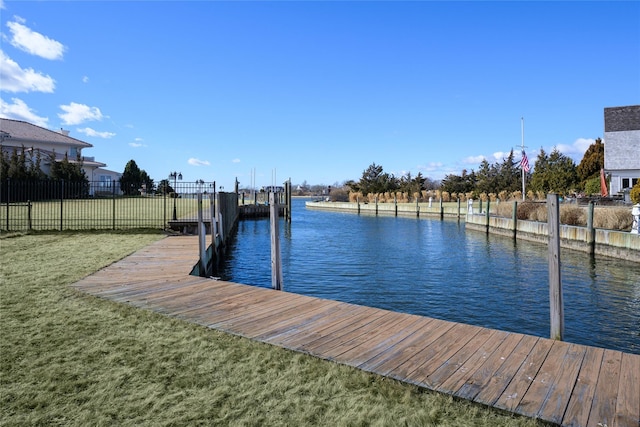 dock area featuring a yard, a water view, and fence