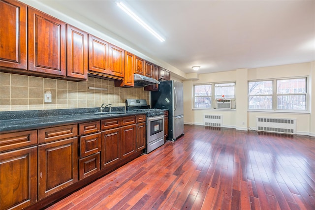 kitchen with radiator, sink, stainless steel appliances, and dark hardwood / wood-style flooring