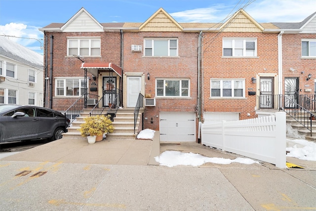 multi unit property featuring a garage and an AC wall unit