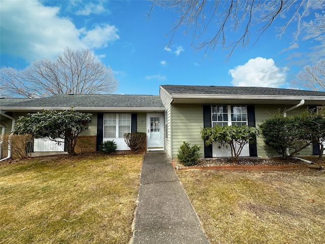 single story home with a front yard, roof with shingles, and brick siding