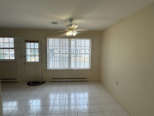 interior space with a baseboard heating unit, a ceiling fan, visible vents, and light tile patterned floors