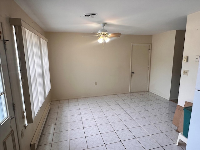 empty room featuring visible vents, baseboard heating, a ceiling fan, and light tile patterned flooring