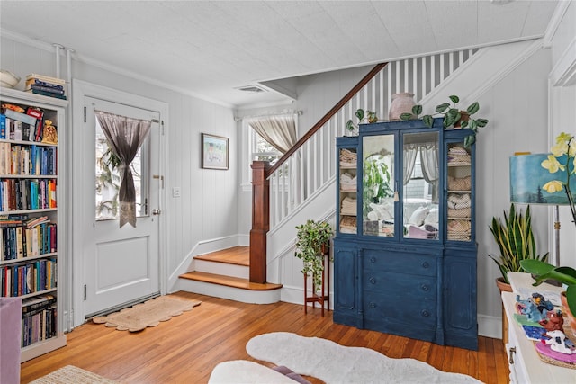 entryway featuring wood-type flooring and crown molding