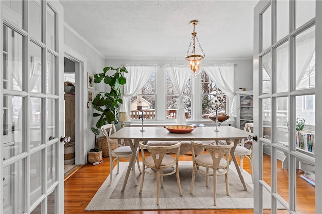 sunroom / solarium featuring french doors and a chandelier