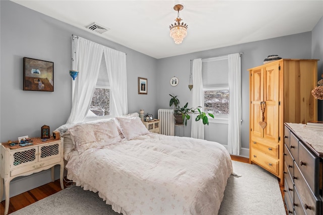 bedroom featuring radiator heating unit and light hardwood / wood-style flooring