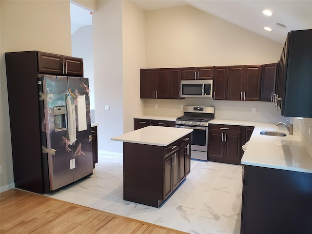 kitchen with sink, a center island, high vaulted ceiling, dark brown cabinets, and stainless steel appliances