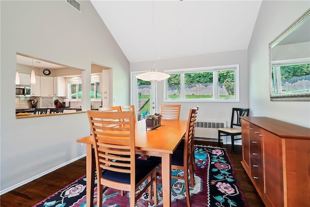 dining area with lofted ceiling, dark wood finished floors, visible vents, and radiator