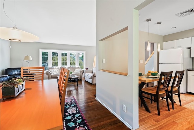 dining space with baseboards, visible vents, and wood finished floors