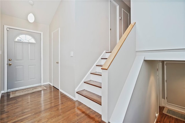 entrance foyer with stairs, wood finished floors, and lofted ceiling