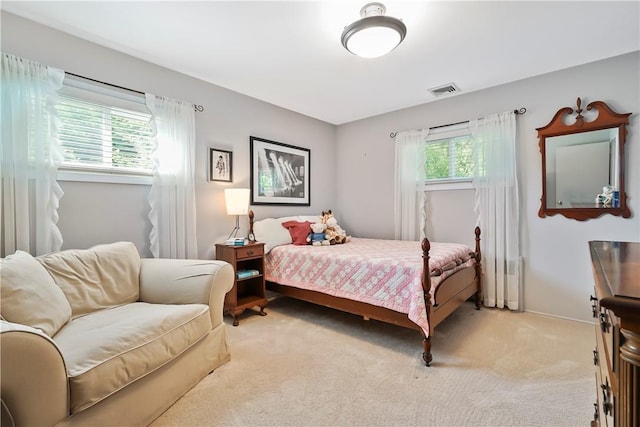 bedroom with light carpet, visible vents, and baseboards