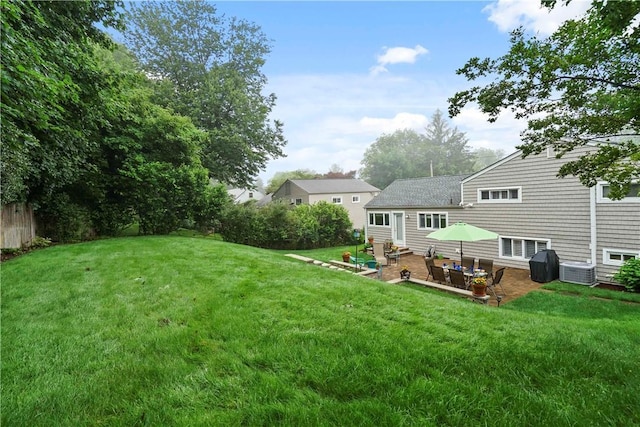 view of yard with fence, central AC, and a patio