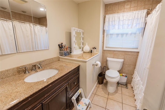 bathroom featuring tile patterned flooring, vanity, tile walls, and toilet