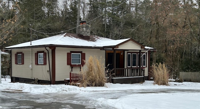 view of front of home with a porch and a chimney