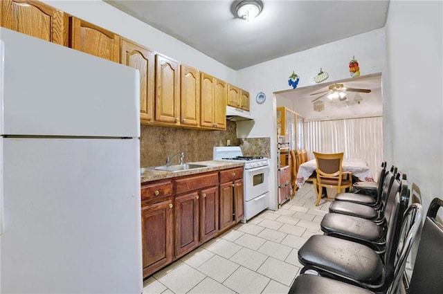 kitchen with sink, backsplash, light tile patterned floors, ceiling fan, and white appliances