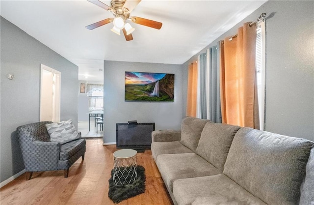 living room featuring hardwood / wood-style floors and ceiling fan