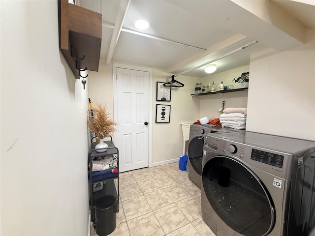 laundry area with laundry area, washing machine and dryer, light tile patterned floors, and baseboards