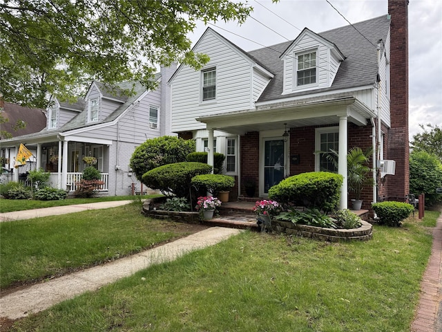 204 N Grove St, Valley Stream, NY 11580 - cape cod home with brick siding, a front lawn, a chimney, and a porch