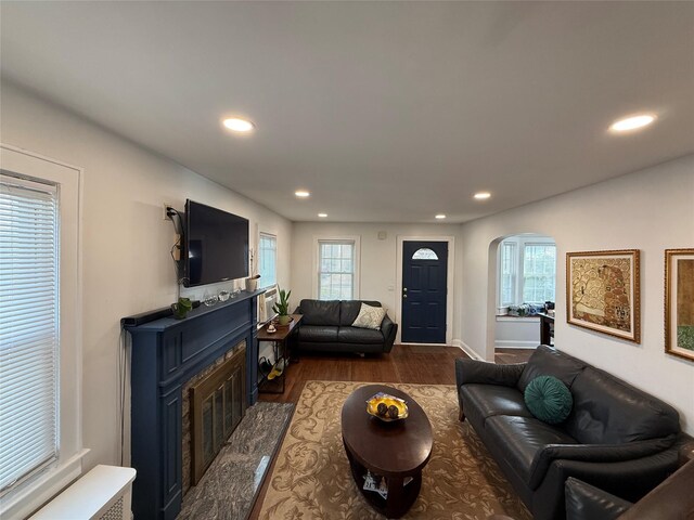 204 N Grove St, Valley Stream, NY 11580 - living room with arched walkways, recessed lighting, a glass covered fireplace, dark wood-style floors, and baseboards