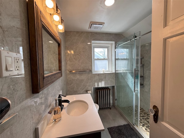 204 N Grove St, Valley Stream, NY 11580 - bathroom featuring radiator, tile walls, vanity, a stall shower, and tile patterned floors
