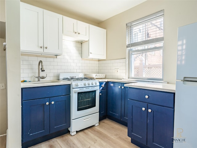 kitchen with blue cabinets, sink, light wood-type flooring, white appliances, and white cabinets