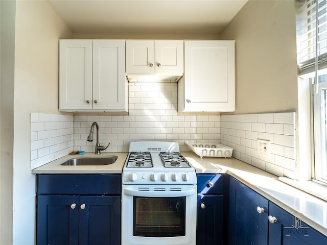 kitchen with sink, white gas range oven, white cabinetry, backsplash, and blue cabinets