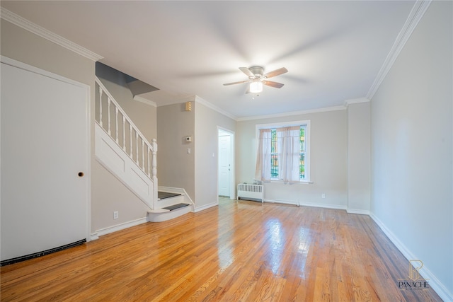 empty room featuring crown molding, ceiling fan, radiator heating unit, and light hardwood / wood-style flooring