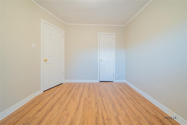 spare room featuring ornamental molding and light hardwood / wood-style floors