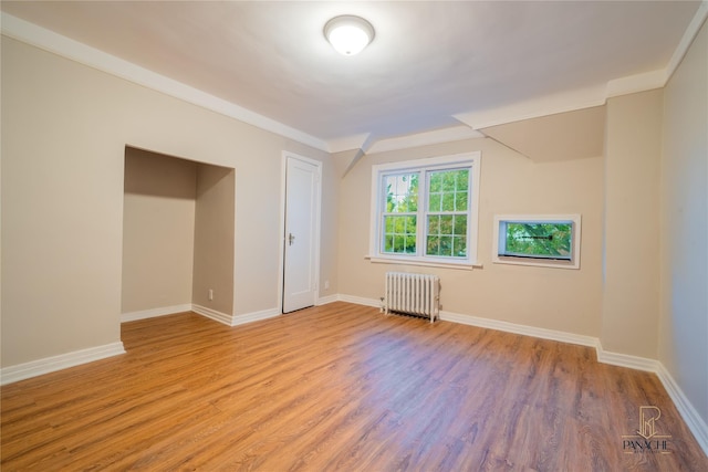 interior space with radiator and light hardwood / wood-style flooring