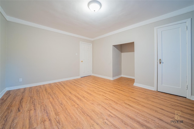 unfurnished room with ornamental molding and light wood-type flooring