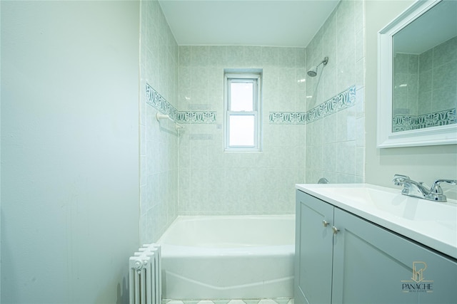 bathroom with vanity, radiator, and tiled shower / bath combo