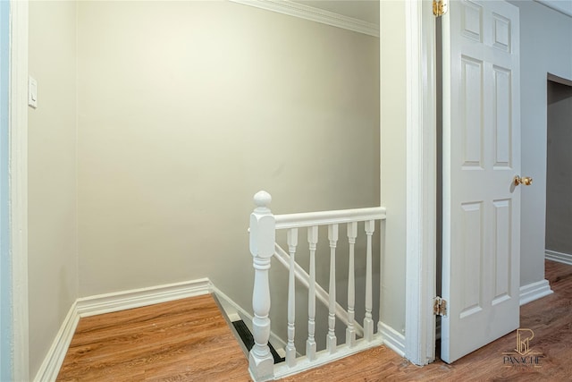 staircase with hardwood / wood-style flooring and ornamental molding