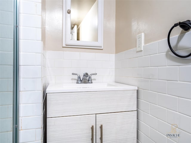 bathroom featuring vanity and tile walls