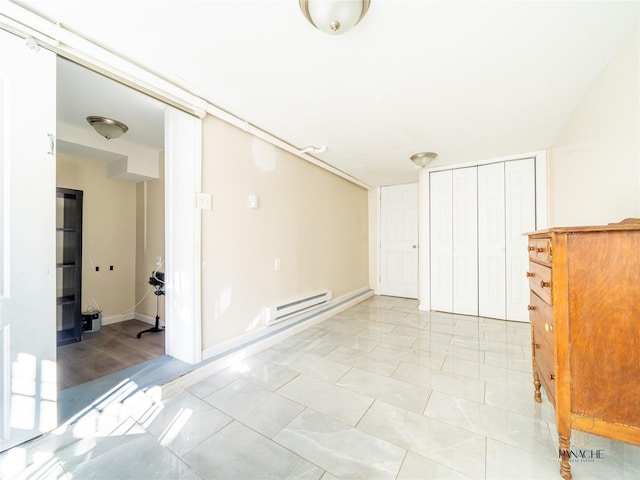 tiled empty room with a baseboard heating unit