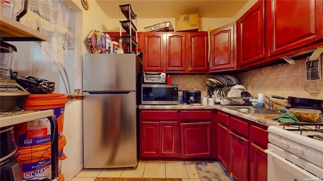 kitchen featuring light tile patterned flooring, stainless steel appliances, sink, and decorative backsplash