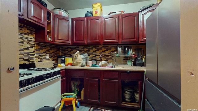 kitchen with white range with gas cooktop, sink, and decorative backsplash